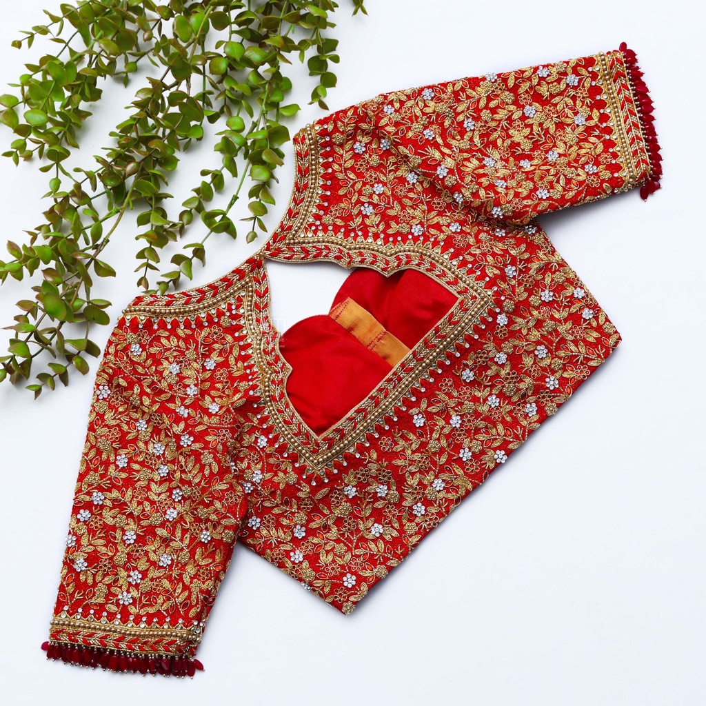 Stunning red blouse adorned with a mesmerizing red and gold pattern. Stitching