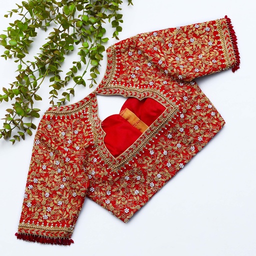 Stunning red blouse adorned with a mesmerizing red and gold pattern. Stitching